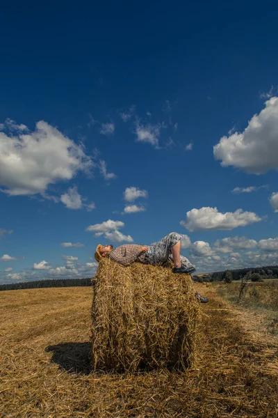Kovboy şapkalı, buğday ekmekli, sakallı genç bir adam.