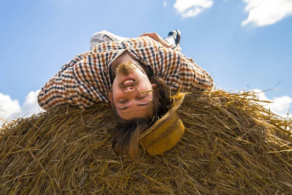 Kovboy şapkalı, buğday ekmekli, sakallı genç bir adam.