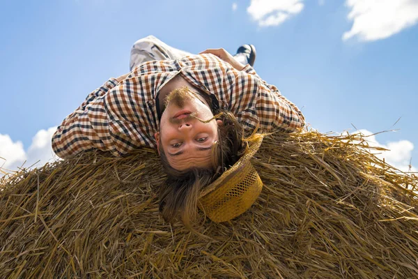 Kovboy şapkalı, buğday ekmekli, sakallı genç bir adam.