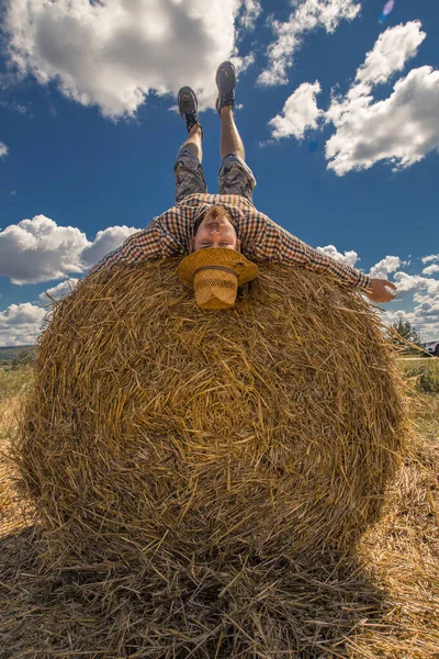 Kovboy şapkalı, buğday ekmekli, sakallı genç bir adam.