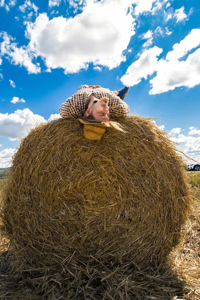 Kovboy şapkalı, buğday ekmekli, sakallı genç bir adam.