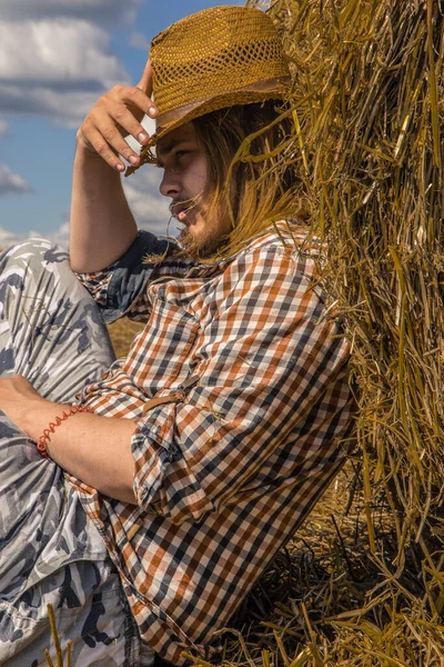 Kovboy şapkalı, buğday ekmekli, sakallı genç bir adam.