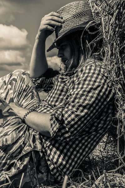 Kovboy şapkalı, buğday ekmekli, sakallı genç bir adam.