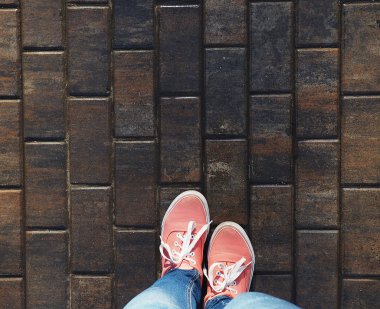 bir çift pembe ayakkabı ıslak asfalt üzerinde.