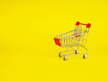 süpermarket alışveriş kavramı sarı arka planda, boş, trolley. Kopya alanı reklam için