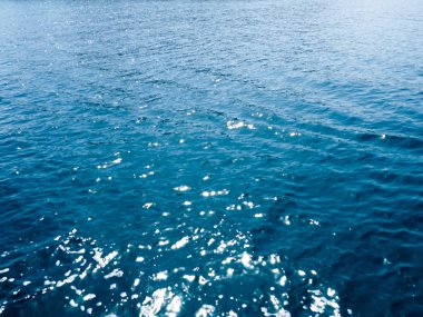 su yüzeyi. Arka plan, deniz suyu güneş ışığı altında. Yaz arka plan. Güneş ışığı bokeh derin turkuaz su Akdeniz deniz bulanık parıldıyor