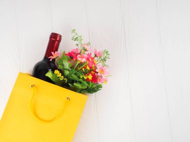 -bir şişe şarap ve paket üzerinde ahşap arka plan, metin için yer çiçek.