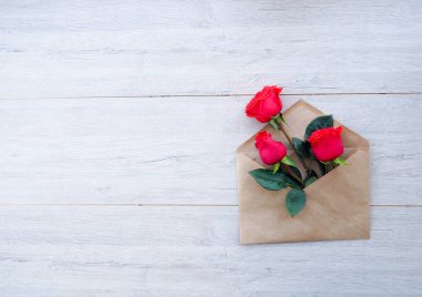 Zarf Kraft kağıt, ahşap arka plan, metin, kutlama düğün, olarak için yer üzerinde çiçekler kırmızı güllü Doğum günü.