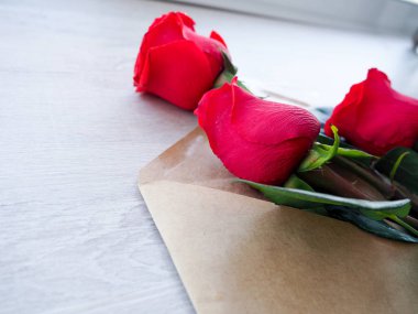 Zarf Kraft kağıt, ahşap arka plan, metin, kutlama düğün, olarak için yer üzerinde çiçekler kırmızı güllü Doğum günü.