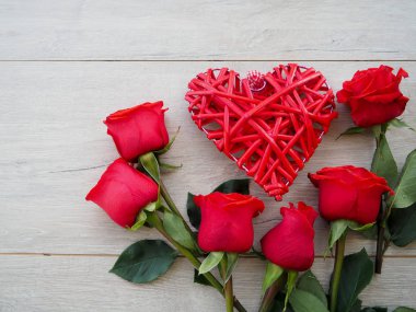 Kurdele ve yay ve ahşap kırmızı güller demet ile hediye kutusu Valentine arka plan. Kopyalama alanı