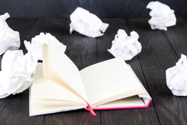Ahşap masada beyaz Not paneli. bloknot yakın çok kırışık kağıt yatıyor.