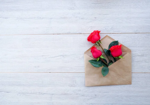 Zarf Kraft kağıt, ahşap arka plan, metin, kutlama düğün, olarak için yer üzerinde çiçekler kırmızı güllü Doğum günü.