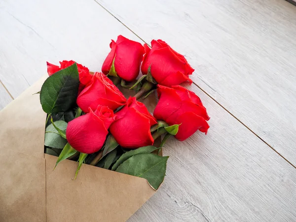 Zarf Kraft kağıt, ahşap arka plan, metin, kutlama düğün, olarak için yer üzerinde çiçekler kırmızı güllü Doğum günü.