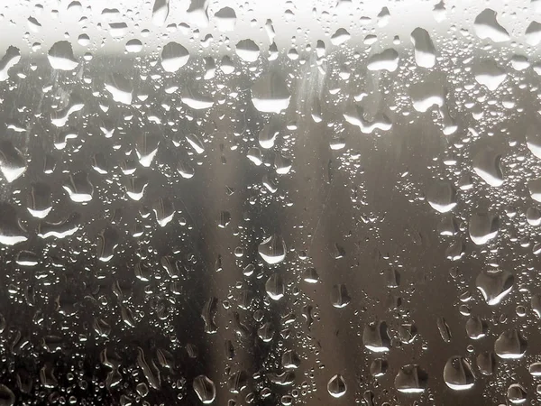 Water drop on the glass of windows background, raining on the glass off window city for background