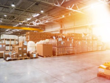bulanıklık malzemeleri ve ahşap depolamak için ambar sanayi tesislerinde, konteynerler için bir forklift vardır. Konsept lojistiği, taşımacılık. Hareket bulanıklaştırma efekti. Parlak güneş ışığı