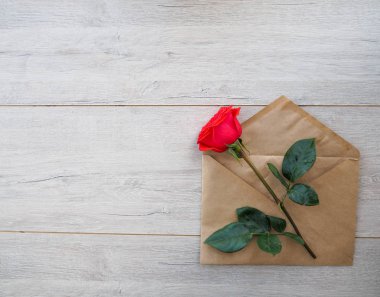 Romantik arka plan ile kırmızı gül, kalp üzerinde ahşap masa, üstten görünüm