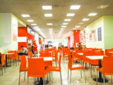 Salonda bulanık insanlar arka plan ile satırda düzenlenmiş boş sarı renk sandalyeler. turuncu sandalyeli yemek odası, bulanık.