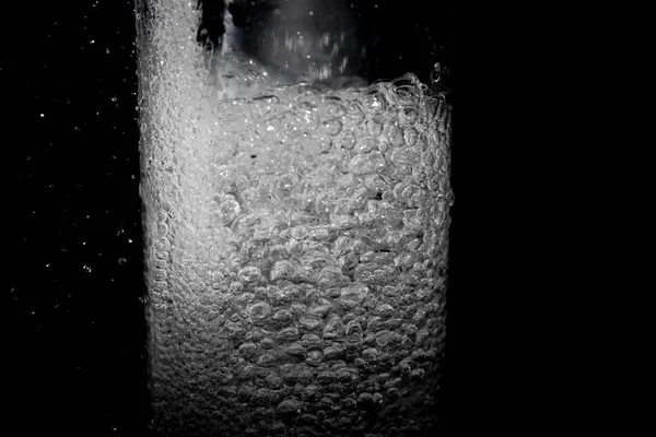 スタイリッシュな黒の水のしぶきが水しぶき 黒の背景 グラスの中の泡の分離 — ストック写真