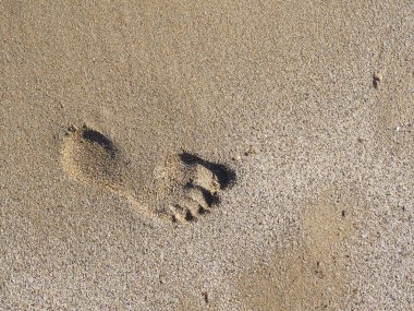 Kumlu plajda ayak izi. bir adamın yaz pistinde sahilde