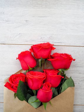 Kraft Kağıt zarf, bir ahşap arka plan üzerinde çiçekler, metin için boşluk, kutlama düğün gibi, Doğum günü