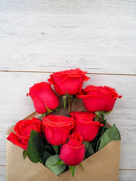 Kraft Kağıt zarf, bir ahşap arka plan üzerinde çiçekler, metin için boşluk, kutlama düğün gibi, Doğum günü