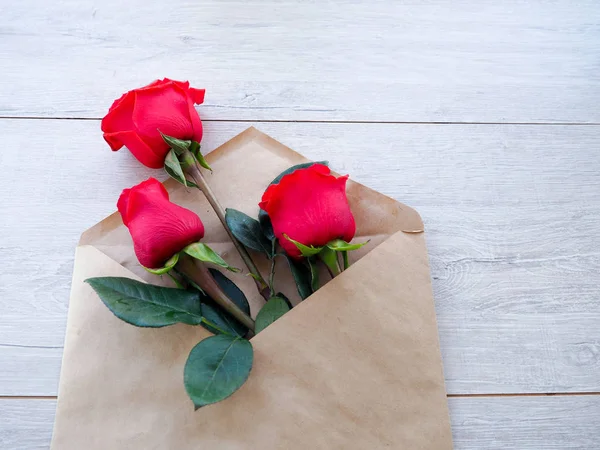 Zarf Kraft kağıt, ahşap arka plan, metin, kutlama düğün, olarak için yer üzerinde çiçekler kırmızı güllü Doğum günü