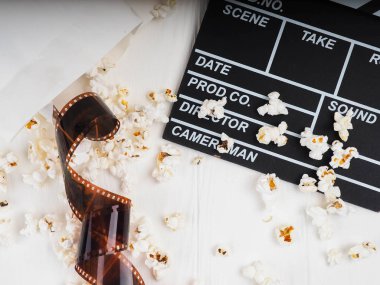 Beyaz ahşap arka planda fotoğraf film şeridi, patlamış mısır