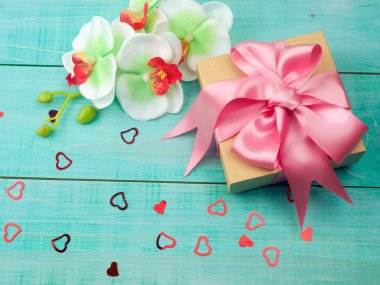 mavi arka planda pembe saten şerit ile hediye kutusu