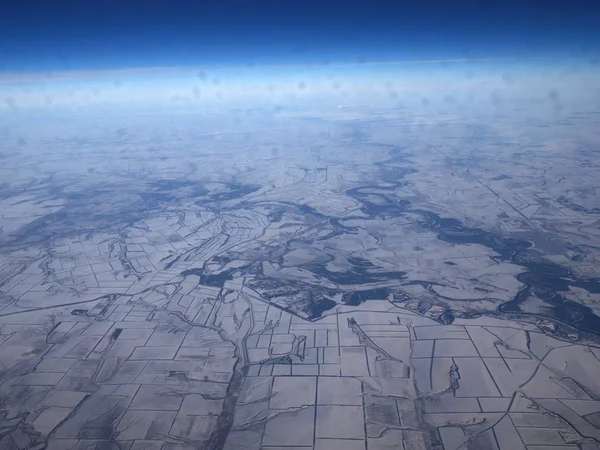 Bulutlarla kaplı karlı dağların havadan görünümü. Dağ üstü uçaktan kış görünümünde bulutlar ile kaplı. — Stok fotoğraf