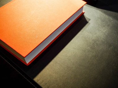 Siyah masa üzerinde kırmızı hardback kitap, Ofis karanlık masa. Sahte kitap boş siyah, kırmızı, beyaz, dergi için deri kapak, kitapçık, broşür, günlük, iş portföyü mock-up tasarım şablonu siyah bac