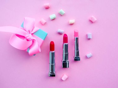 Moda konsepti : Pembe sevimli kadın çanta ruj Düz yatıyordu, kremler, bal, marshmallow, kopya alanı ile renkli arka plan üzerinde toz