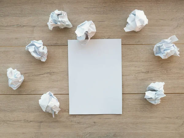 Concepto de escritura - trozos de papel arrugados con una hoja de papel blanco — Foto de Stock