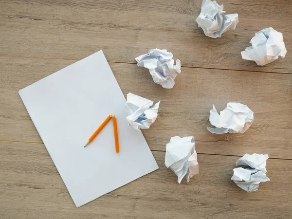 Concepto de escritura - trozos de papel arrugados con una hoja de papel blanco y lápiz — Foto de Stock