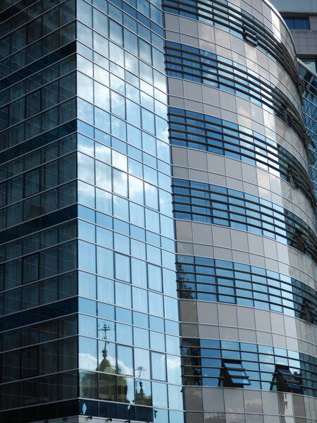 Modern building glass windows with sky reflection.
