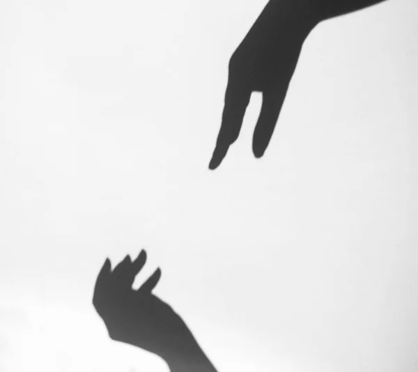 Two women's hands reach for each other. Helping hand silhouette, female and male together — Stock Photo, Image