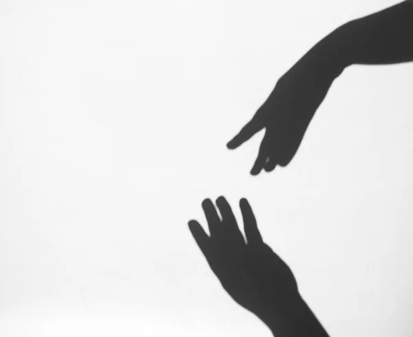 Two women's hands reach for each other. Helping hand silhouette, female and male together — Stock Photo, Image