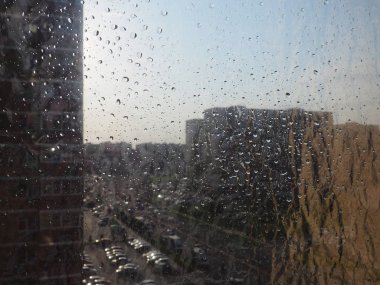 Cam ve şehir arka planında su damlası.