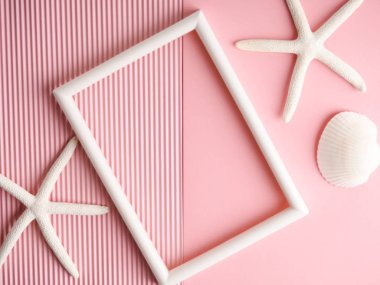 Pembe kıvrımlı kağıt üzerinde beyaz deniz kabukları ve deniz yıldızı, boşluğu kopyala