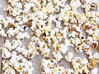 Tahta arka planda patlamış mısır, kopyalama alanı, tuzlanmış patlamış mısır, doku arka planı.