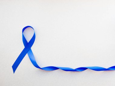 Beyaz arka planda iz bırakan mavi farkındalık kurdelesi, kalın bağırsak için koyu mavi kurdele - kolorektal kanser ve Akut Solunum Sıkıntısı Sendromu destekçilerinin elinde farkındalık yaratıyor