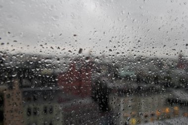 açık cam pencere üzerinde yağmur damla, bulanık şehir yansıması ve dışarıdan ışık bokeh, arka plan için güzel renk soyut