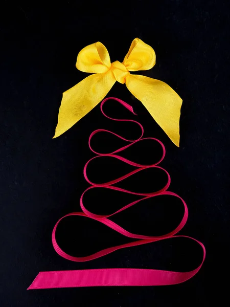 Kerstboom met satijnen linten, op zwarte achtergrond, copy Spa — Stockfoto