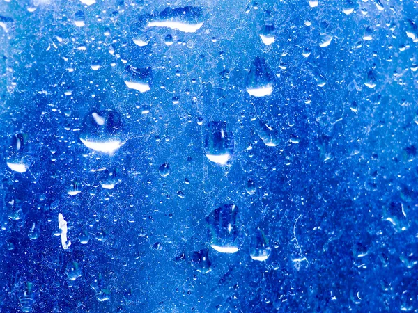 Kropla deszczu na przezroczystym szklanym oknie, odbicie niewyraźne miasto i światło bokeh z zewnątrz, piękny kolor abstrakcyjny dla tła — Zdjęcie stockowe