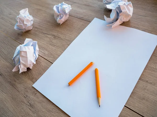 Concepto de escritura - trozos de papel arrugados con una hoja de papel blanco y lápiz — Foto de Stock