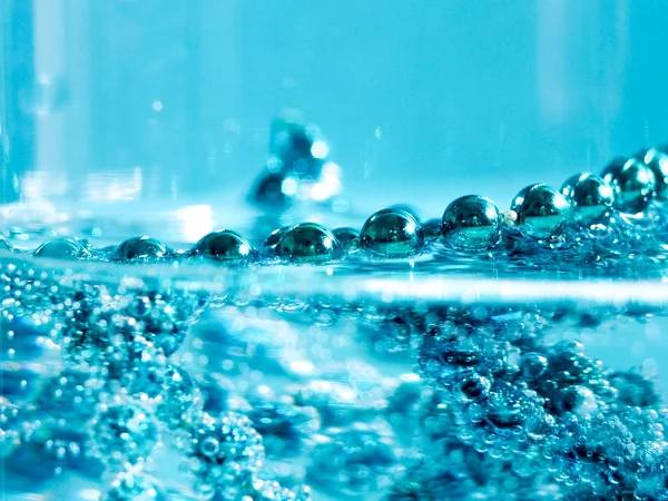 Blauwe kralen in water met belletjes, kerstkaart, abstractie — Stockfoto