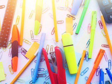 Kağıt zımba, ataç, not, kalem ve kalemler masaya.