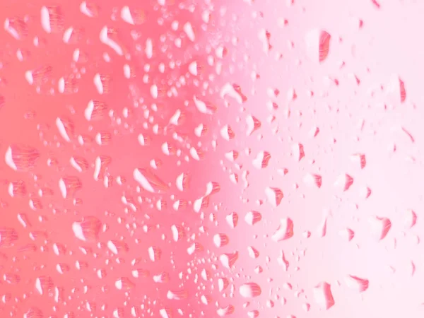 Сосредоточьтесь на капли воды на цветном стекле. Тесное внимание на капли воды на красочные стекла окна в синем и розовом — стоковое фото