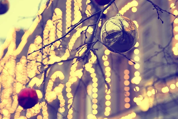 Rozmazané pozadí ulice vánoční strom. Vánoční míče, věnce a ozdoby na smrkových stromech. Street vánoční stromeček, vánoční koule, věnce a dekorace na smrku — Stock fotografie