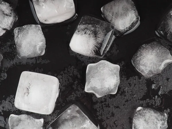 Kostki lodu na czarnym tle stołu z kroplami wody. — Zdjęcie stockowe