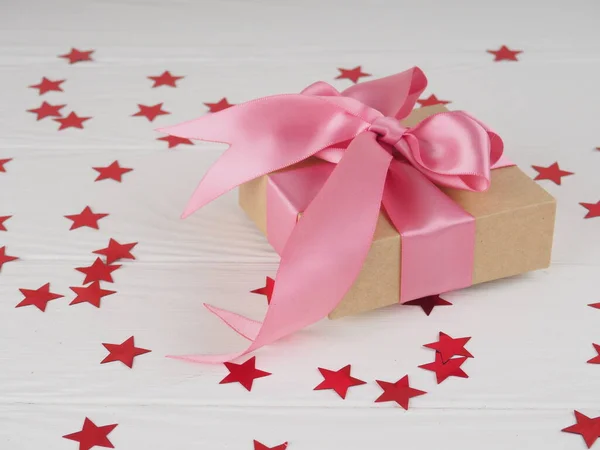 Geschenkdoos met felrood roze lint op witte achtergrond met sterren. ruimte voor tekst naar briefkaart — Stockfoto
